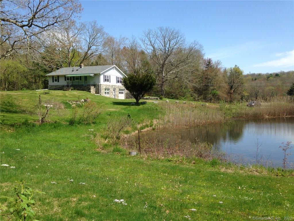 131 Elliott Road Brooklyn, CT 06234 - Photo 1 of 1 a view of a house next to a lake with a big yard