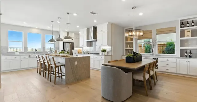 a dining room with stainless steel appliances kitchen island a table and chairs