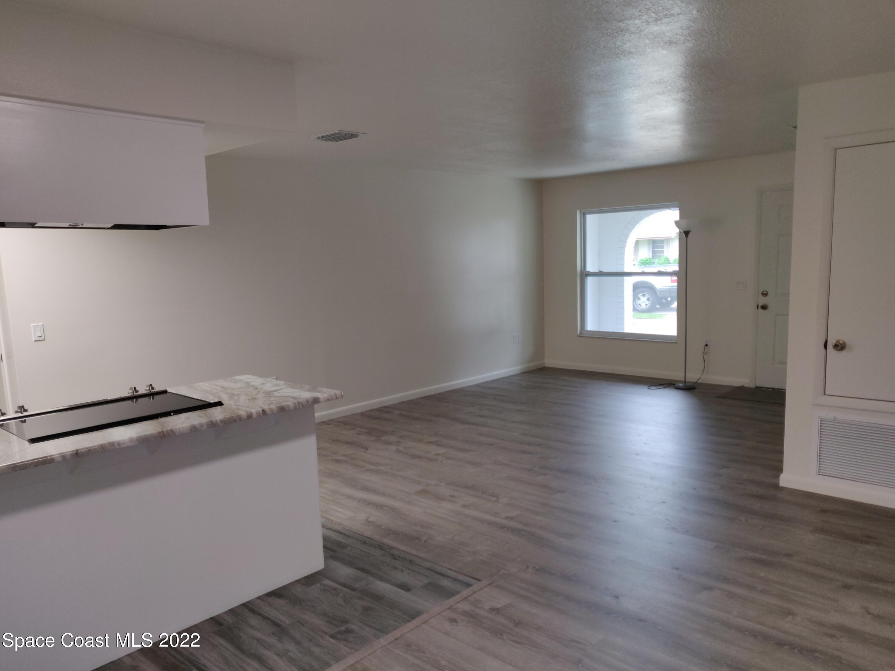3649 Longbow Road Cocoa, FL 32926 - Photo 11 of 34 an empty room with wooden floor and windows
