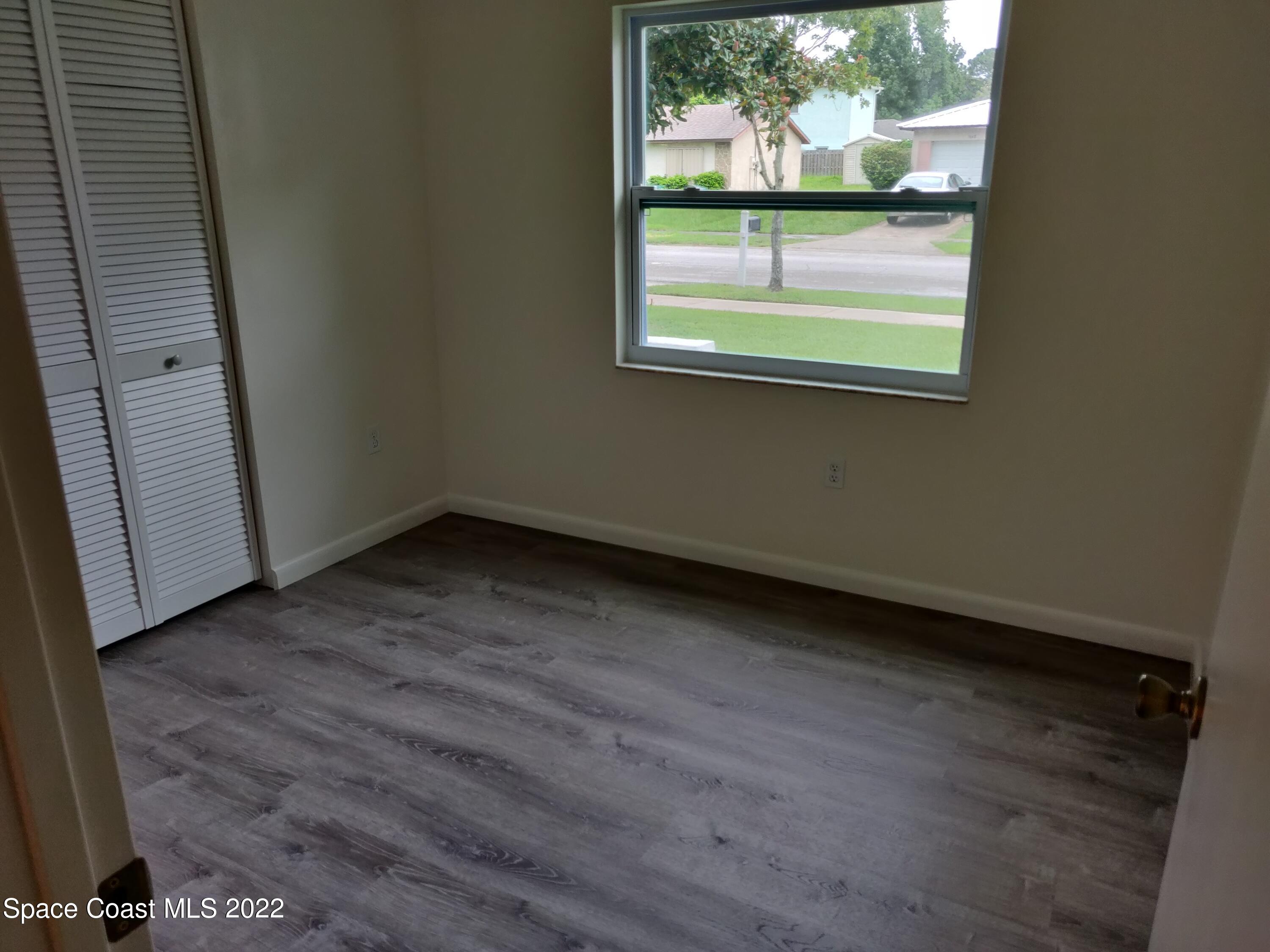 3649 Longbow Road Cocoa, FL 32926 - Photo 15 of 34 an empty room with wooden floor and windows