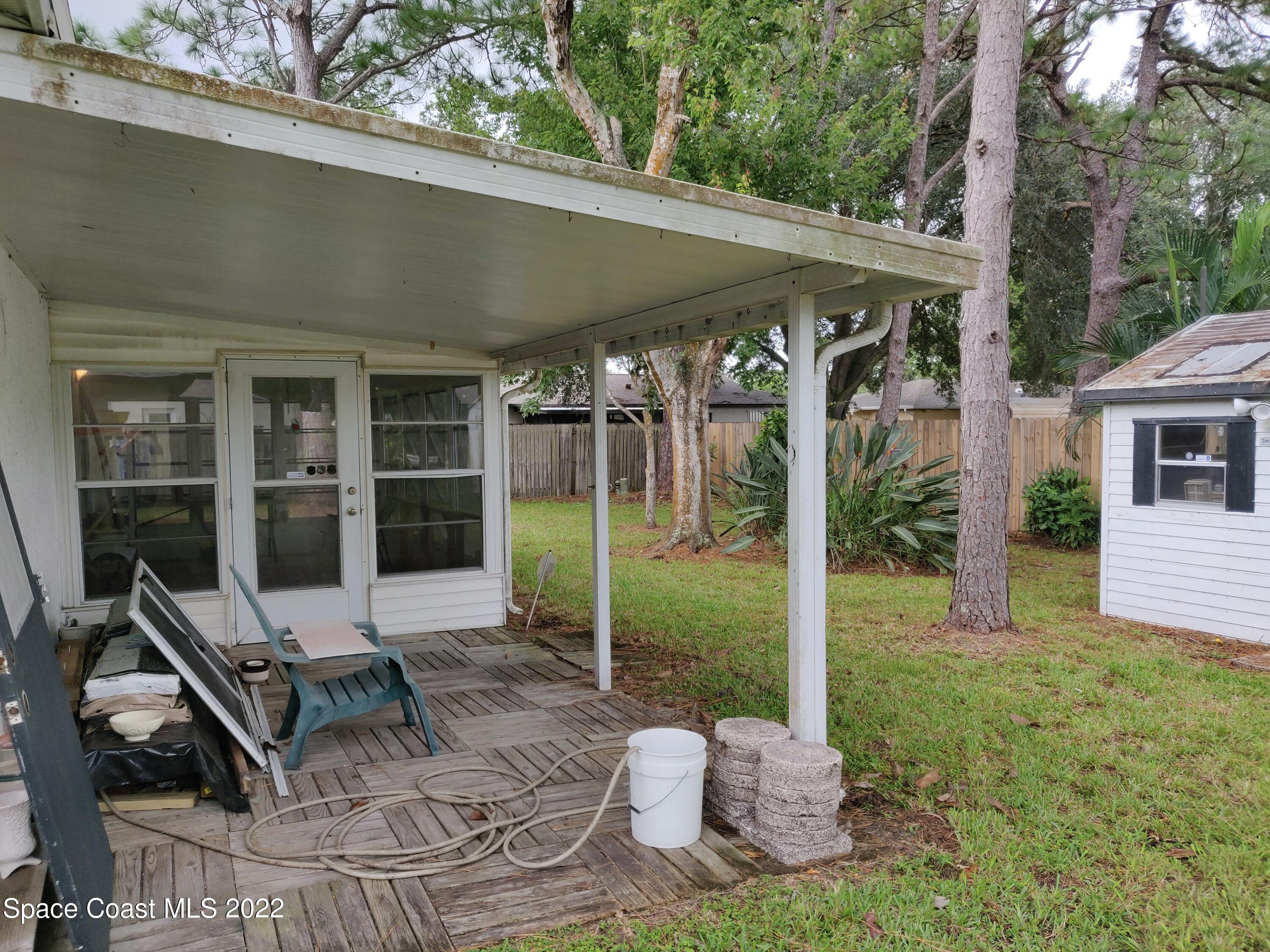 3649 Longbow Road Cocoa, FL 32926 - Photo 26 of 34 a view of a patio with table and chairs wooden floor and fence