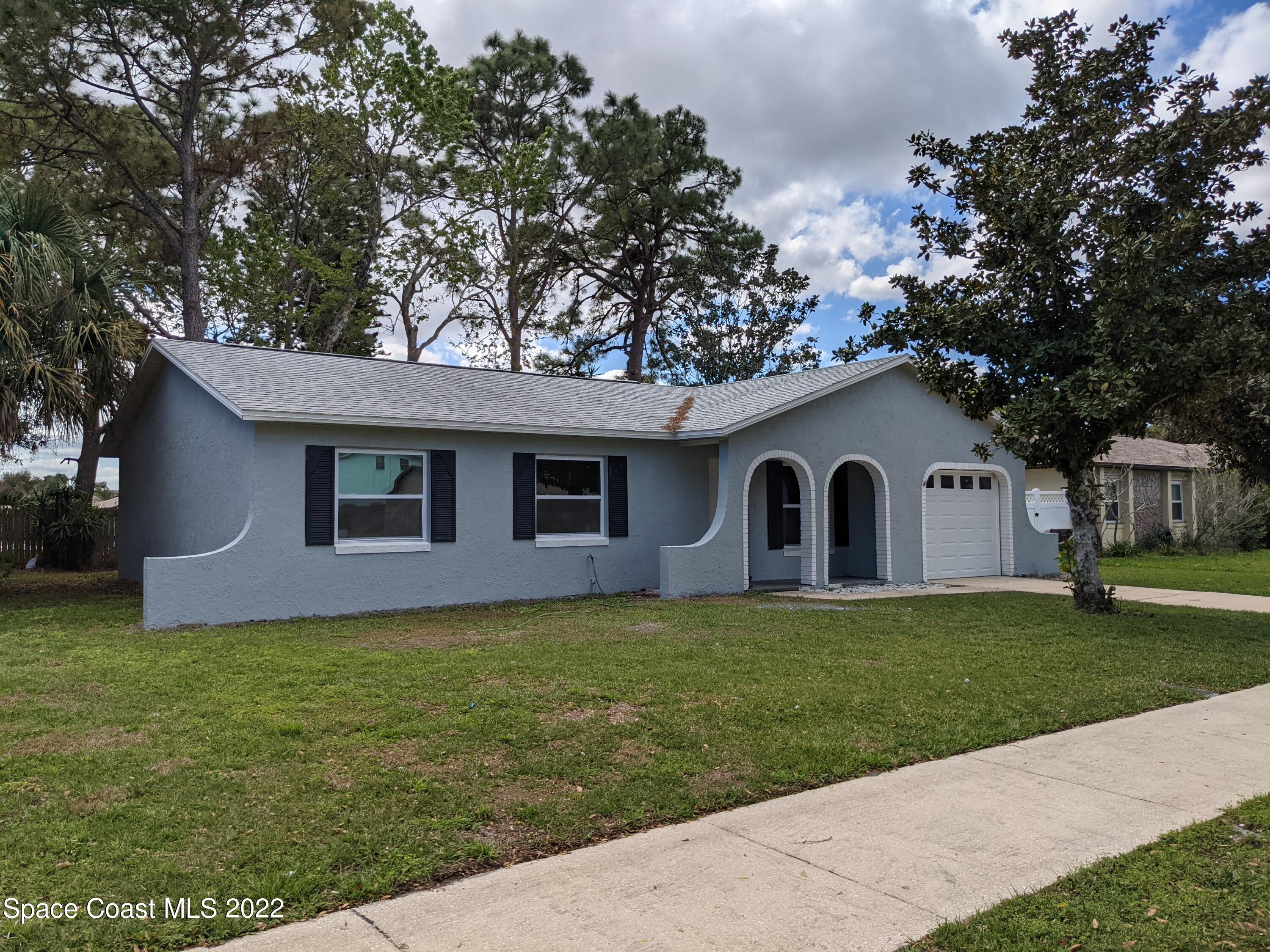 3649 Longbow Road Cocoa, FL 32926 - Photo 33 of 34 a house that is sitting in the grass with large trees