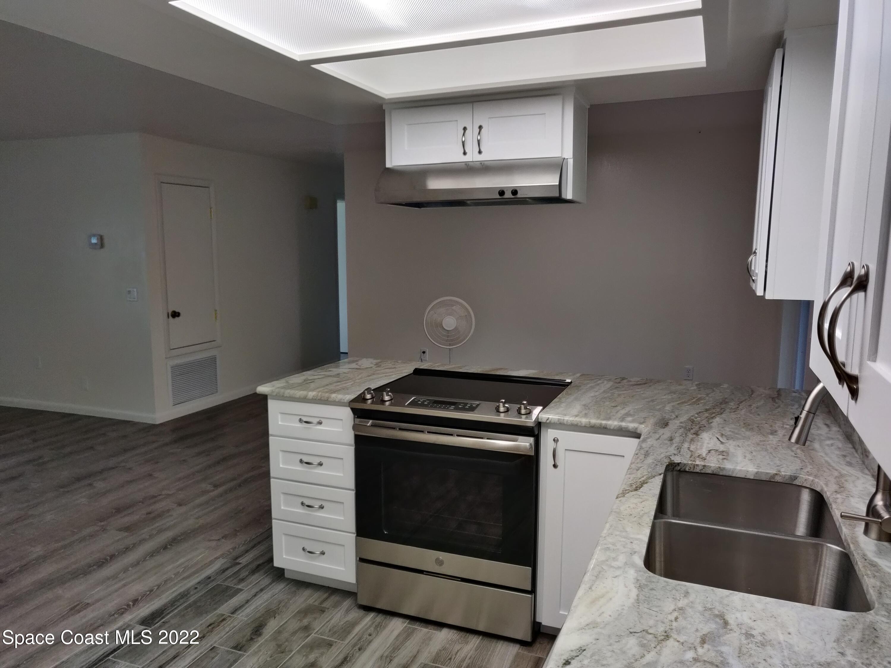 3649 Longbow Road Cocoa, FL 32926 - Photo 6 of 34 a kitchen with stainless steel appliances granite countertop a stove and a sink