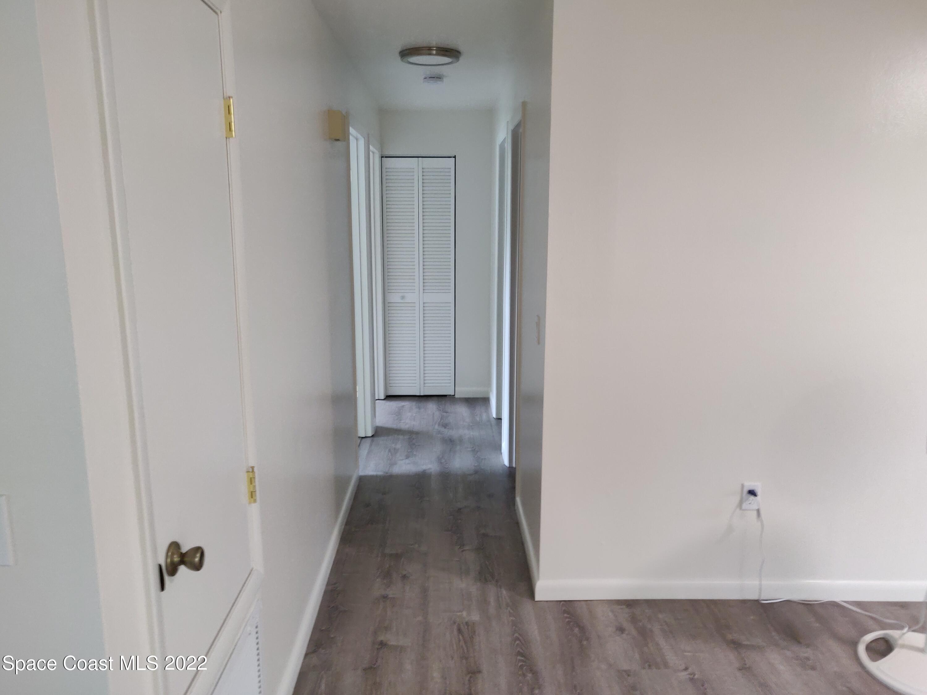 3649 Longbow Road Cocoa, FL 32926 - Photo 9 of 34 a view of a hallway with wooden floor
