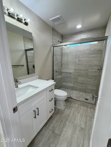 an empty room with a ceiling fan and wooden floor