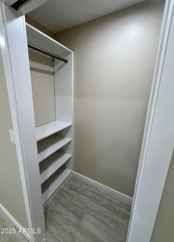 an empty room with wooden floor and entrance