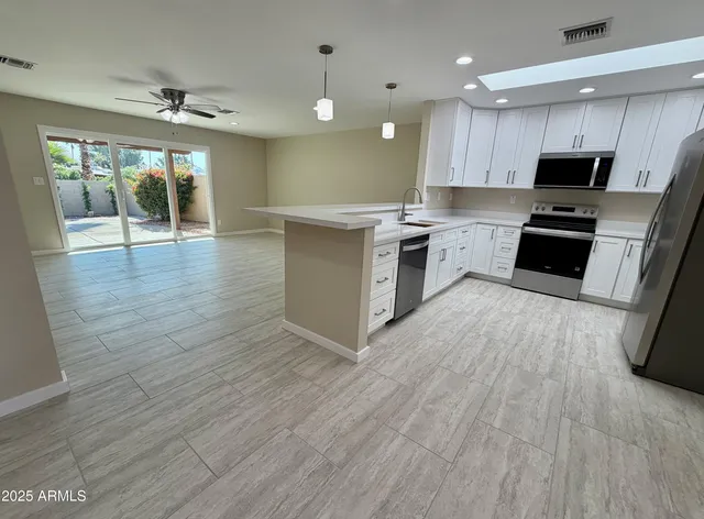 a kitchen with stainless steel appliances a refrigerator sink and microwave
