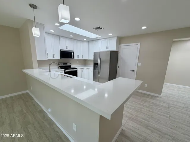 a kitchen with cabinets appliances and a counter space