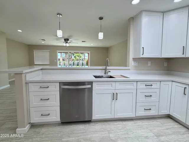 a kitchen with cabinets stainless steel appliances and wooden floor