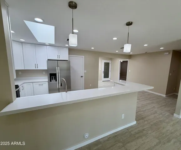 a view of kitchen and empty room with kitchen view