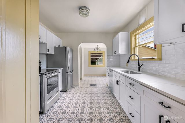 a kitchen with stainless steel appliances granite countertop a sink stove and refrigerator