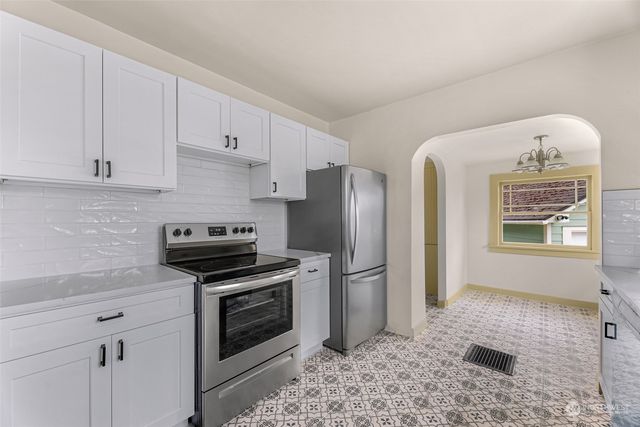 a kitchen with stainless steel appliances granite countertop a refrigerator sink and stove