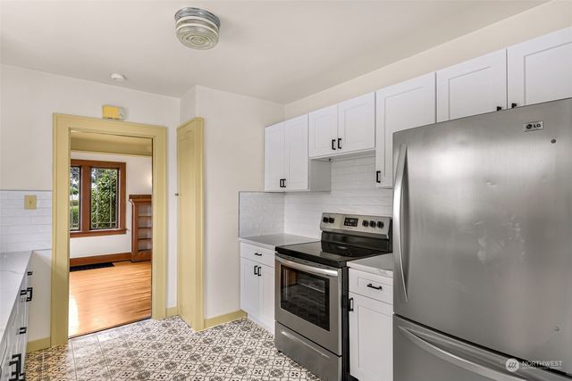 a kitchen with a refrigerator and a stove top oven