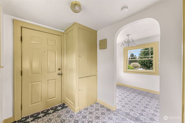 a view of a hallway with wooden floor and a bathroom