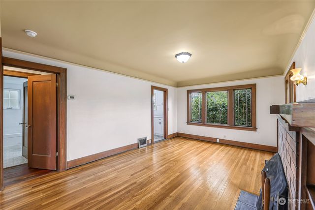 an empty room with wooden floor and a window