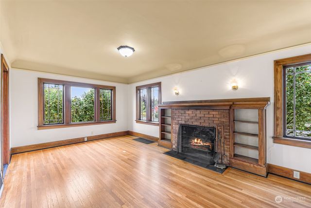 wooden floor fireplace and windows in an empty room