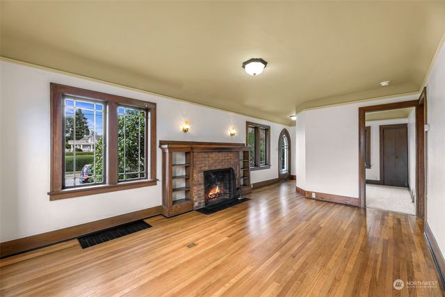 wooden floor fireplace and windows in an empty room