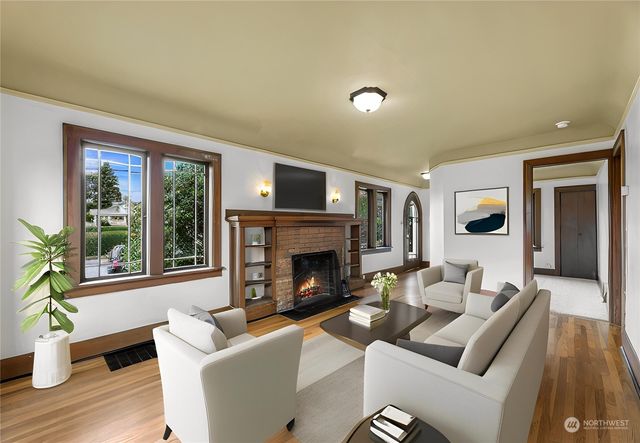 a living room with furniture a fireplace and a large window