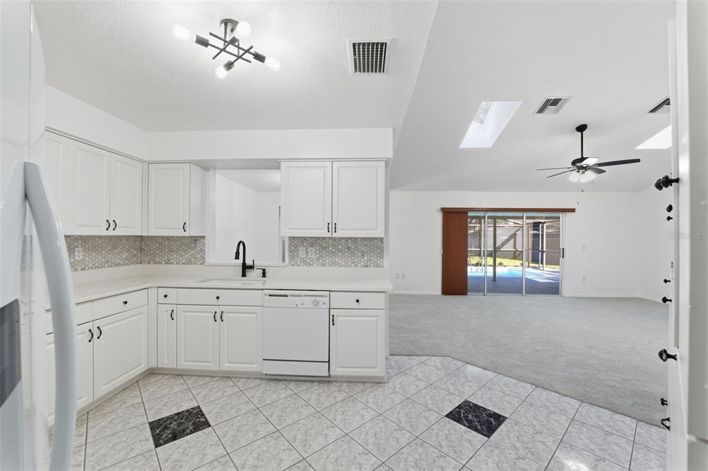 12515 Shadow Ridge Boulevard Hudson, FL 34669 - Photo 13 of 43 a large white kitchen with cabinets and furniture