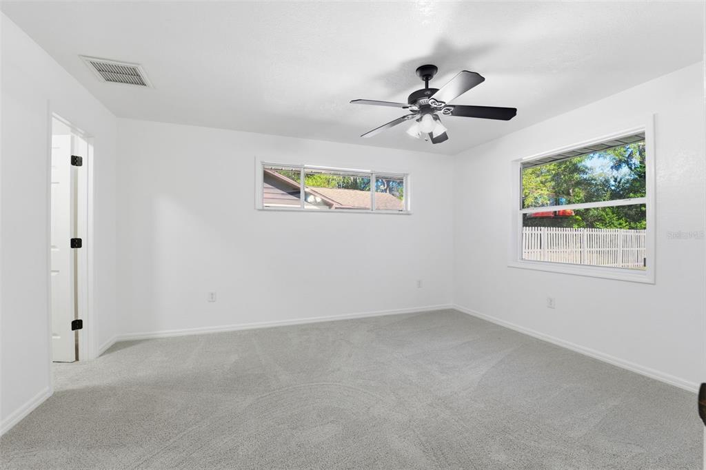 12515 Shadow Ridge Boulevard Hudson, FL 34669 - Photo 16 of 43 an empty room with windows and fan