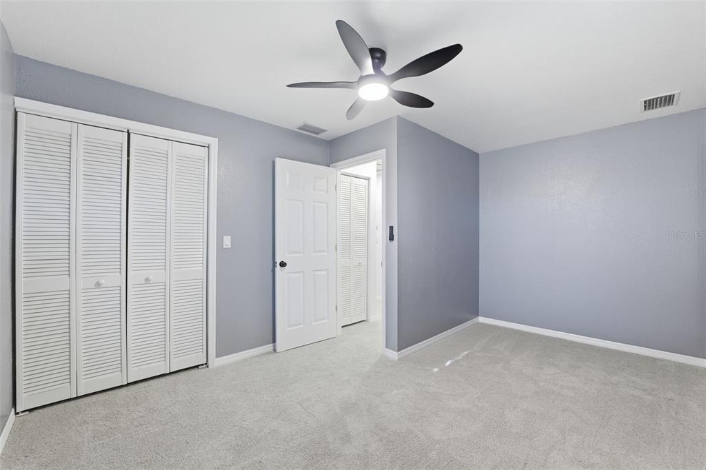12515 Shadow Ridge Boulevard Hudson, FL 34669 - Photo 23 of 43 an empty room with ceiling fan and window