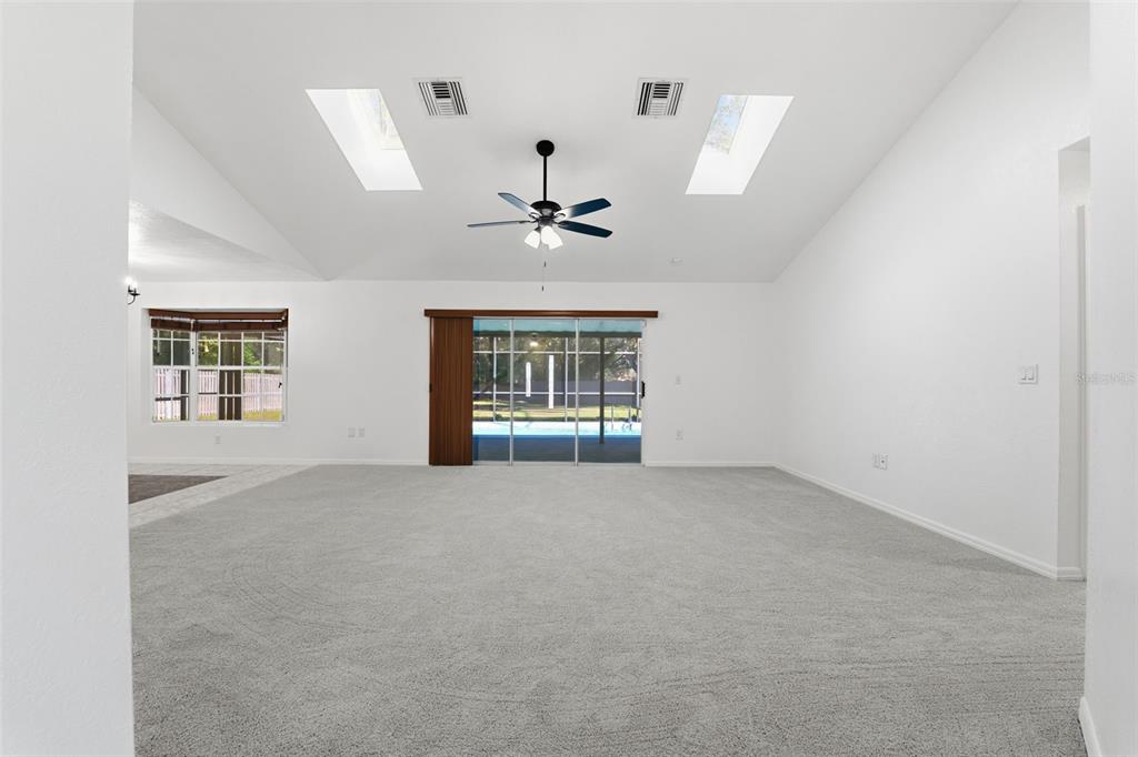 12515 Shadow Ridge Boulevard Hudson, FL 34669 - Photo 5 of 43 an empty room with windows and ceiling fan