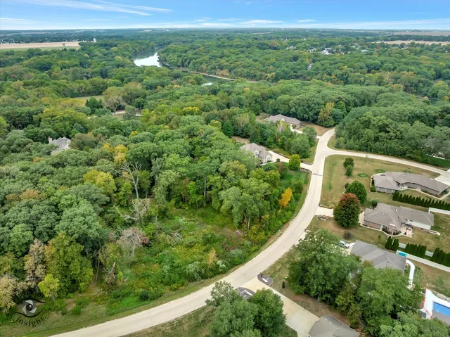a view of a lush green forest with trees and houses