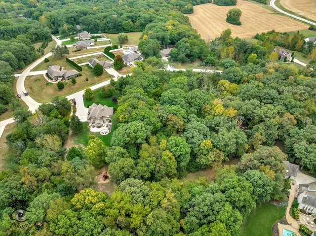 an aerial view of residential house with outdoor space and trees all around