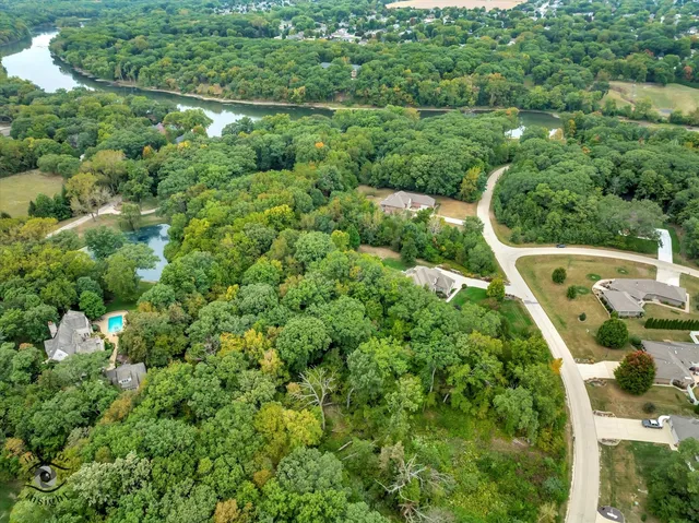 an aerial view of residential houses with outdoor space and trees