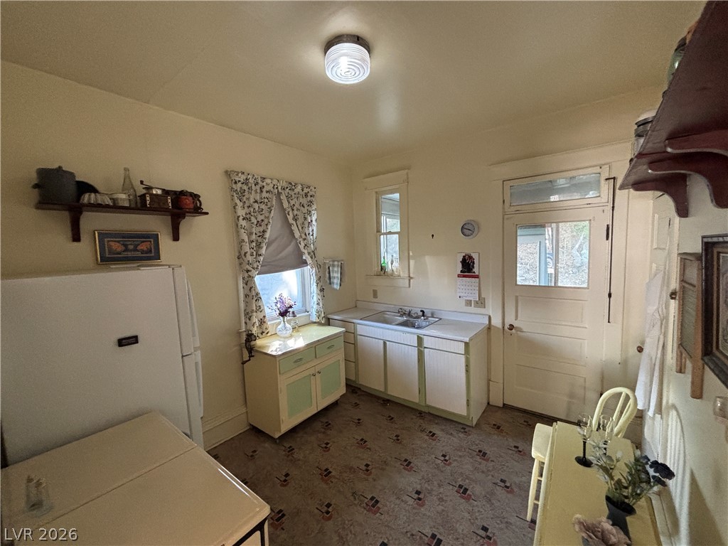 591 Campton Street Ely, NV 89301 - Photo 15 of 29 Kitchen featuring freestanding refrigerator and white cabinetry