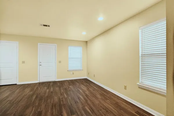 a view of a room with wooden floor and a window
