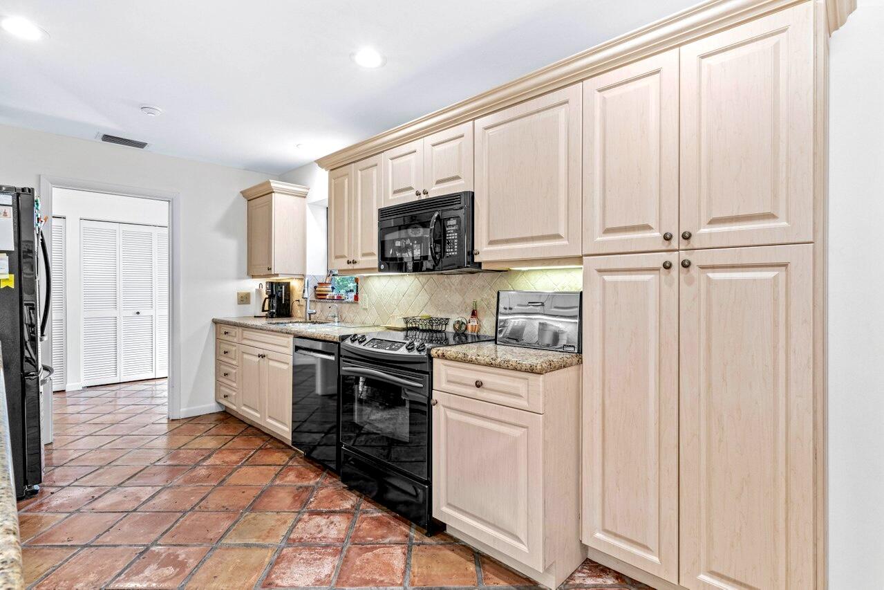 19 Glens Drive West Boynton Beach, FL 33436 - Photo 19 of 69 a kitchen with stainless steel appliances granite countertop a stove a sink and a refrigerator