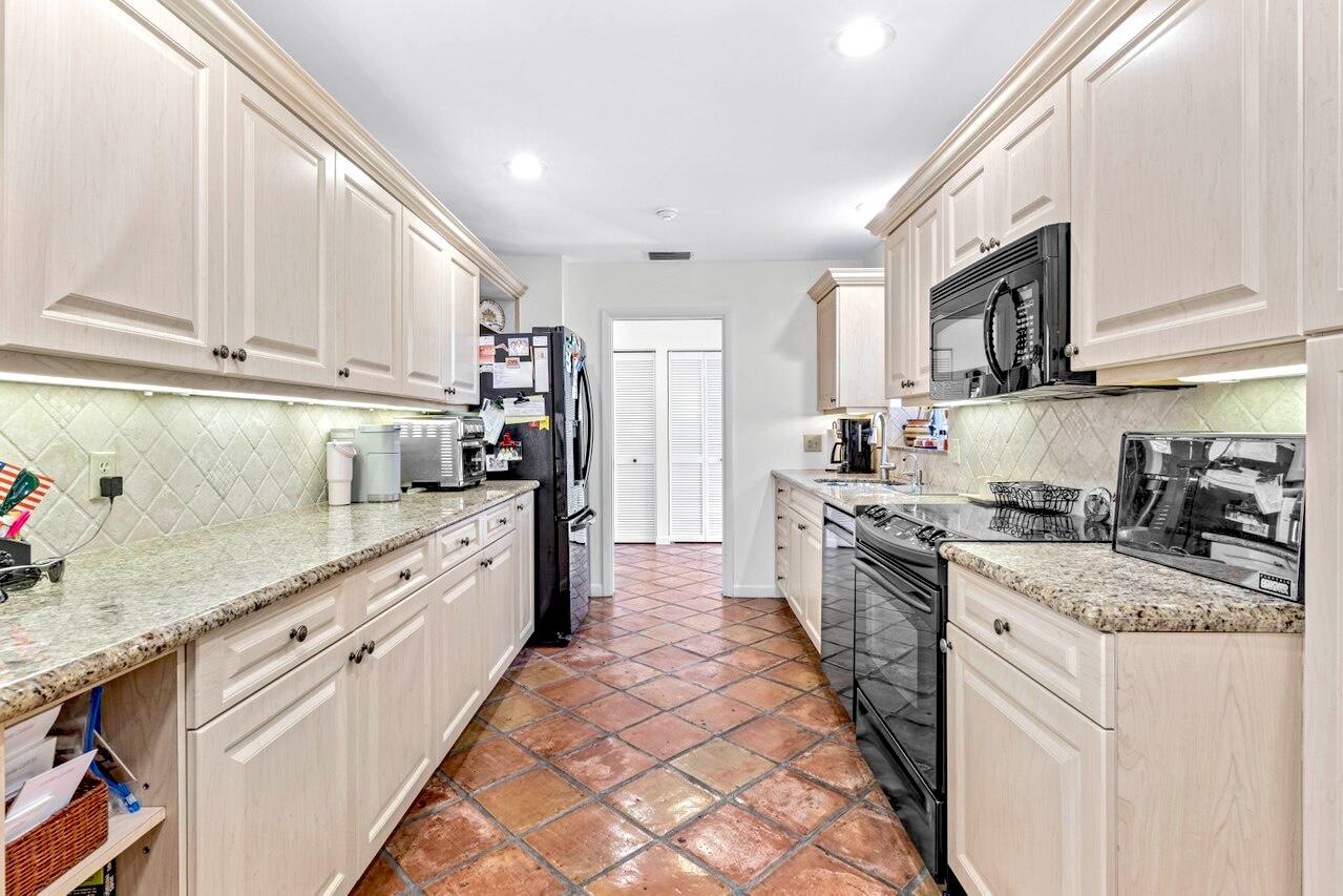 19 Glens Drive West Boynton Beach, FL 33436 - Photo 22 of 69 a kitchen with stainless steel appliances granite countertop a sink stove and refrigerator
