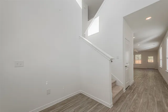 a view of a hallway with wooden floor and staircase