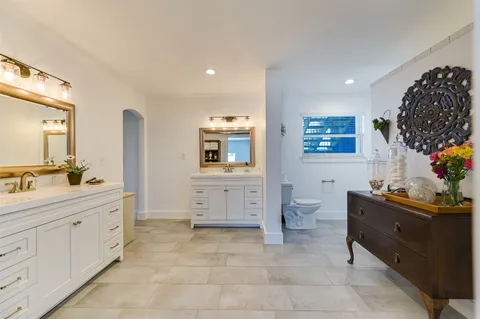 a spacious bathroom with a toilet sink and mirror