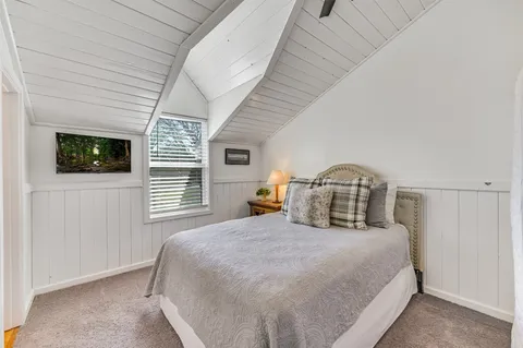 a bedroom with a large bed and a tv