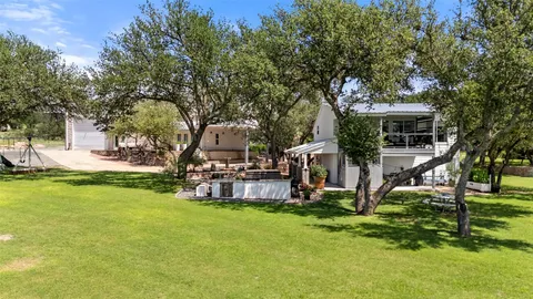 a view of a house with backyard and a tree
