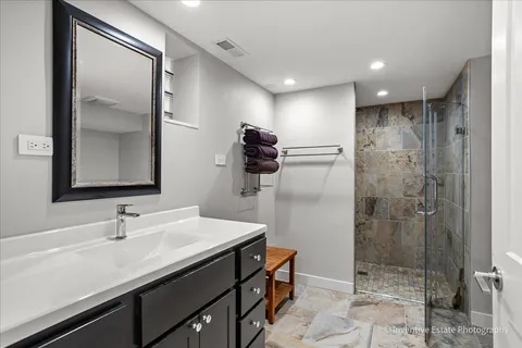 a bathroom with a sink shower and a mirror