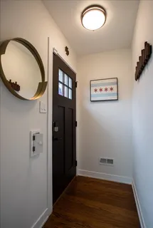 an empty room with wooden floor and mirror