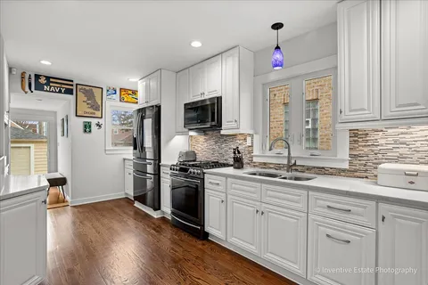 a kitchen with granite countertop a sink stainless steel appliances and cabinets