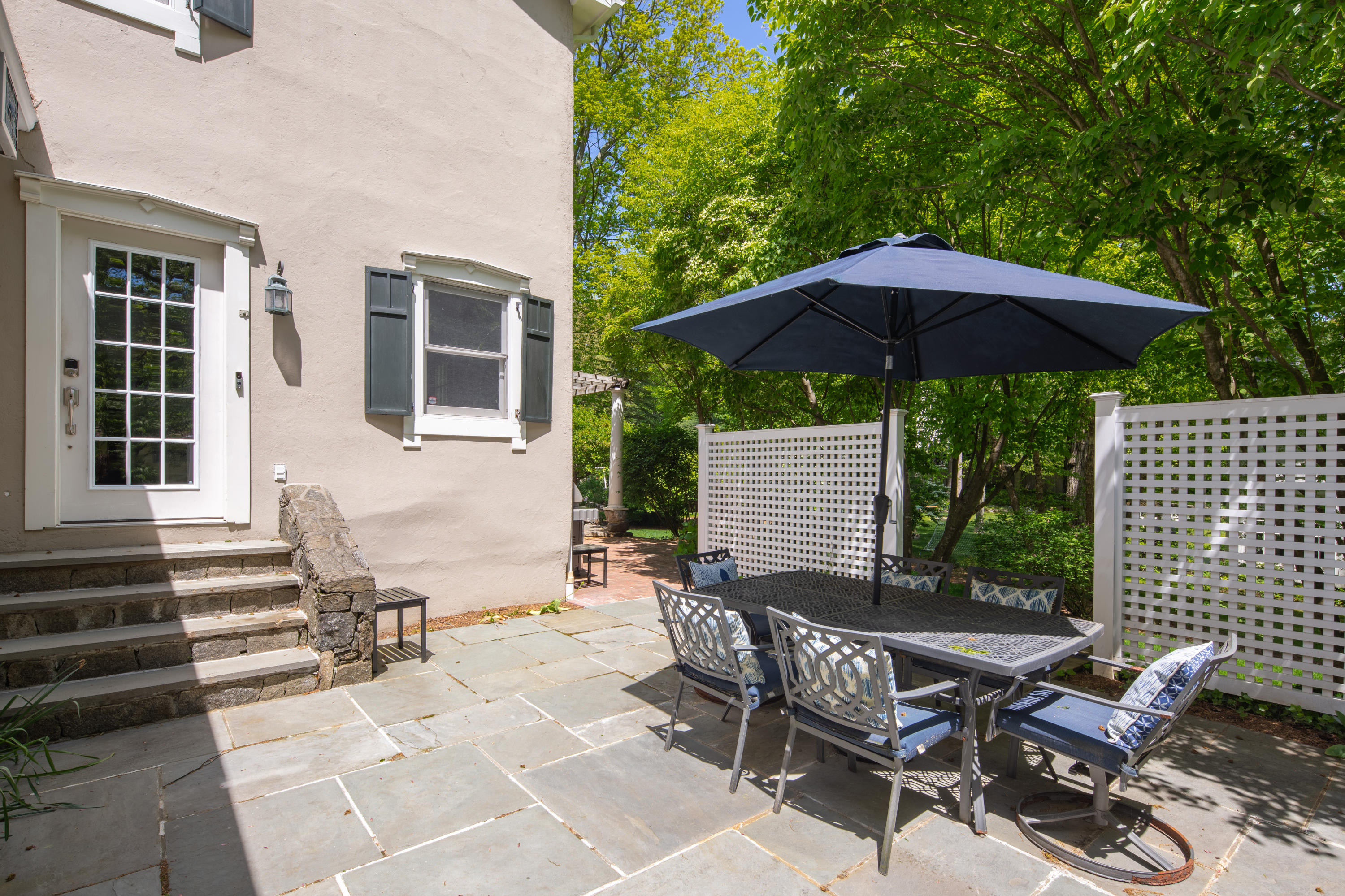 16 Barringer Road Darien, CT 06820 - Photo 4 of 43 a patio with tables and chairs under an umbrella