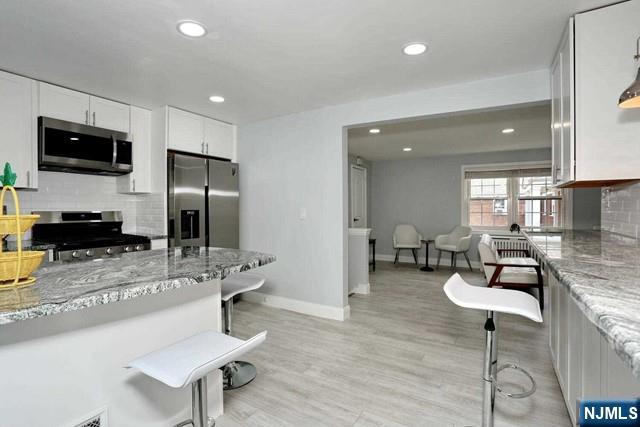 100 Huguenot Avenue, Unit 6B Englewood, NJ 07631 - Photo 15 of 24 a kitchen with stainless steel appliances kitchen island granite countertop a sink and chairs