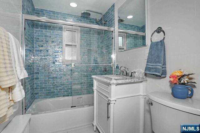 100 Huguenot Avenue, Unit 6B Englewood, NJ 07631 - Photo 4 of 24 a bathroom with a sink mirror and a bathtub