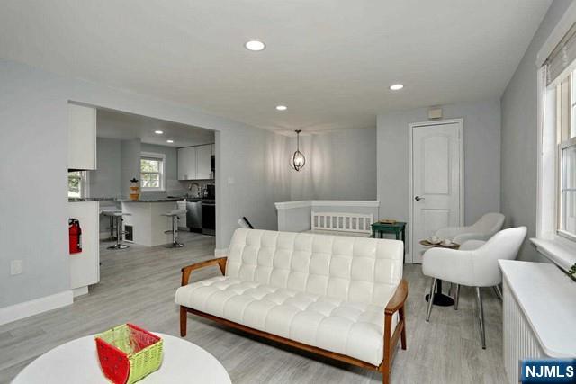 100 Huguenot Avenue, Unit 6B Englewood, NJ 07631 - Photo 9 of 24 a living room with furniture and a dining table with wooden floor