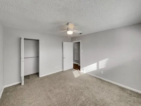 a view of an empty room with closet and a window