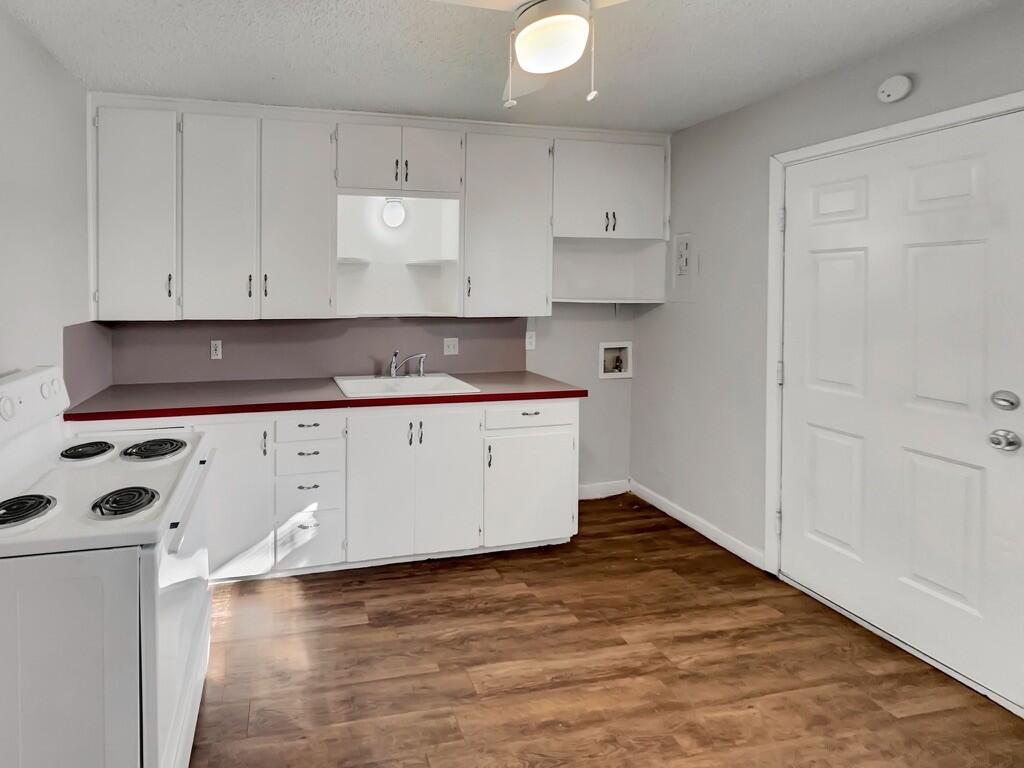 2107 35th Street, Unit B Lubbock, TX 79412 - Photo 4 of 18 a kitchen with granite countertop white cabinets and a stove