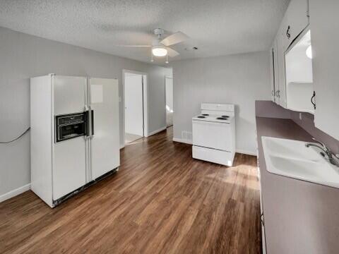 2107 35th Street, Unit B Lubbock, TX 79412 - Photo 7 of 18 a kitchen with wooden floors and white appliances