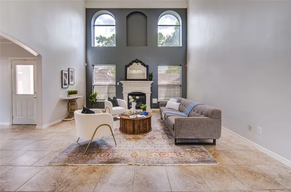 a living room with furniture a fireplace and a large mirror next to a window
