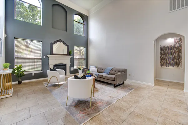 a living room with furniture a fireplace and a potted plant