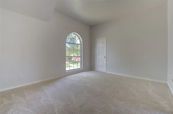an empty room with windows and chandelier